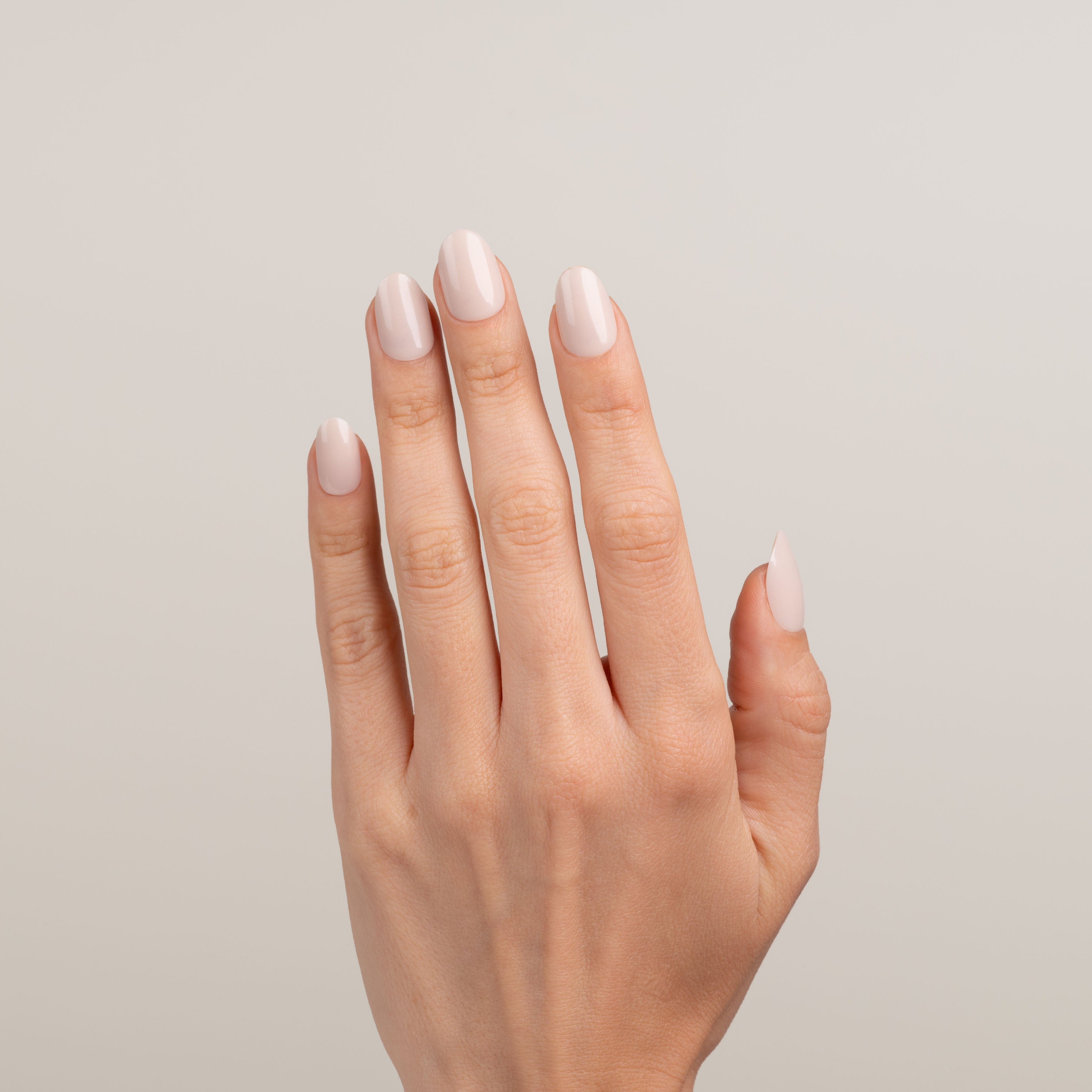 Hand with light pink nail polish