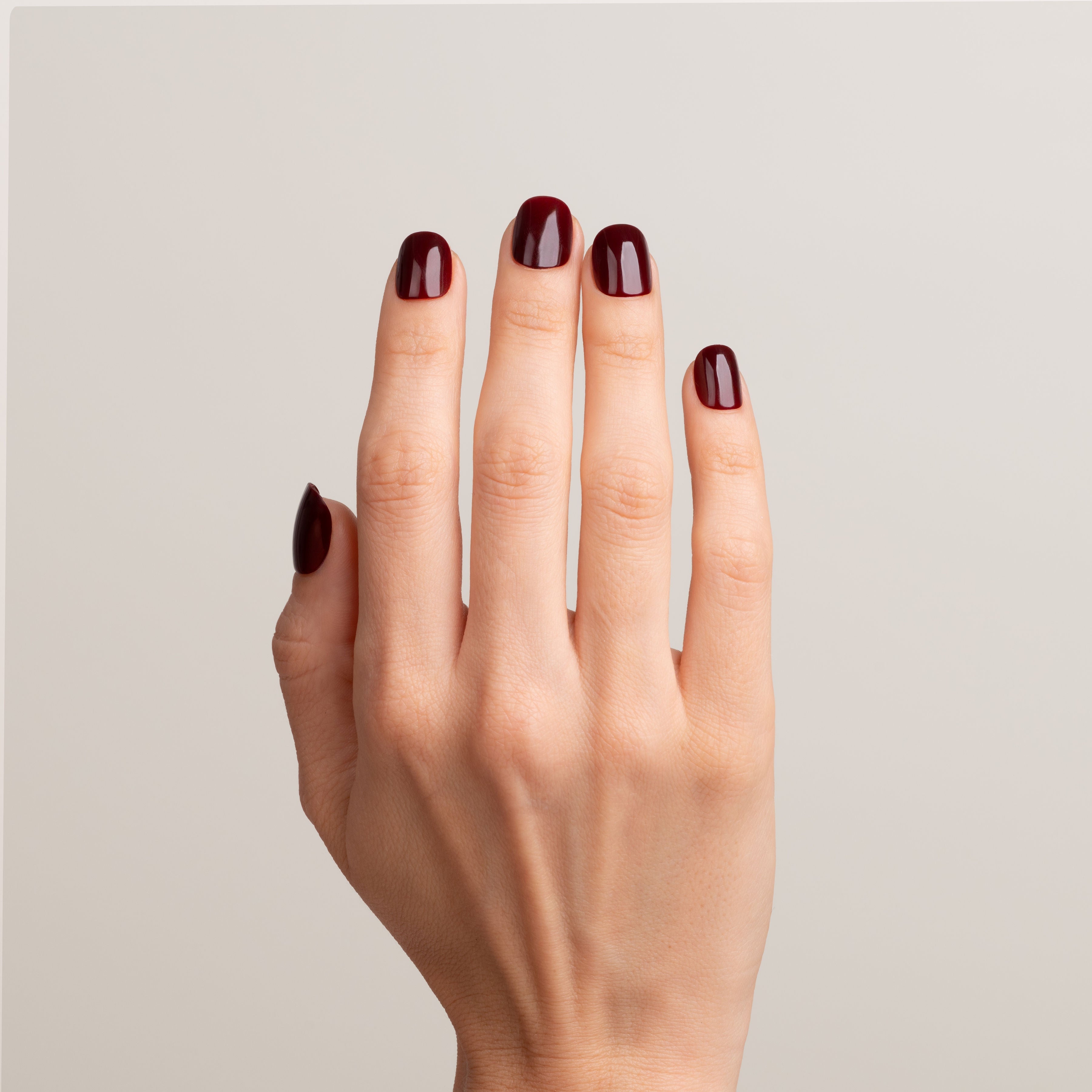 Hand with dark red nail polish