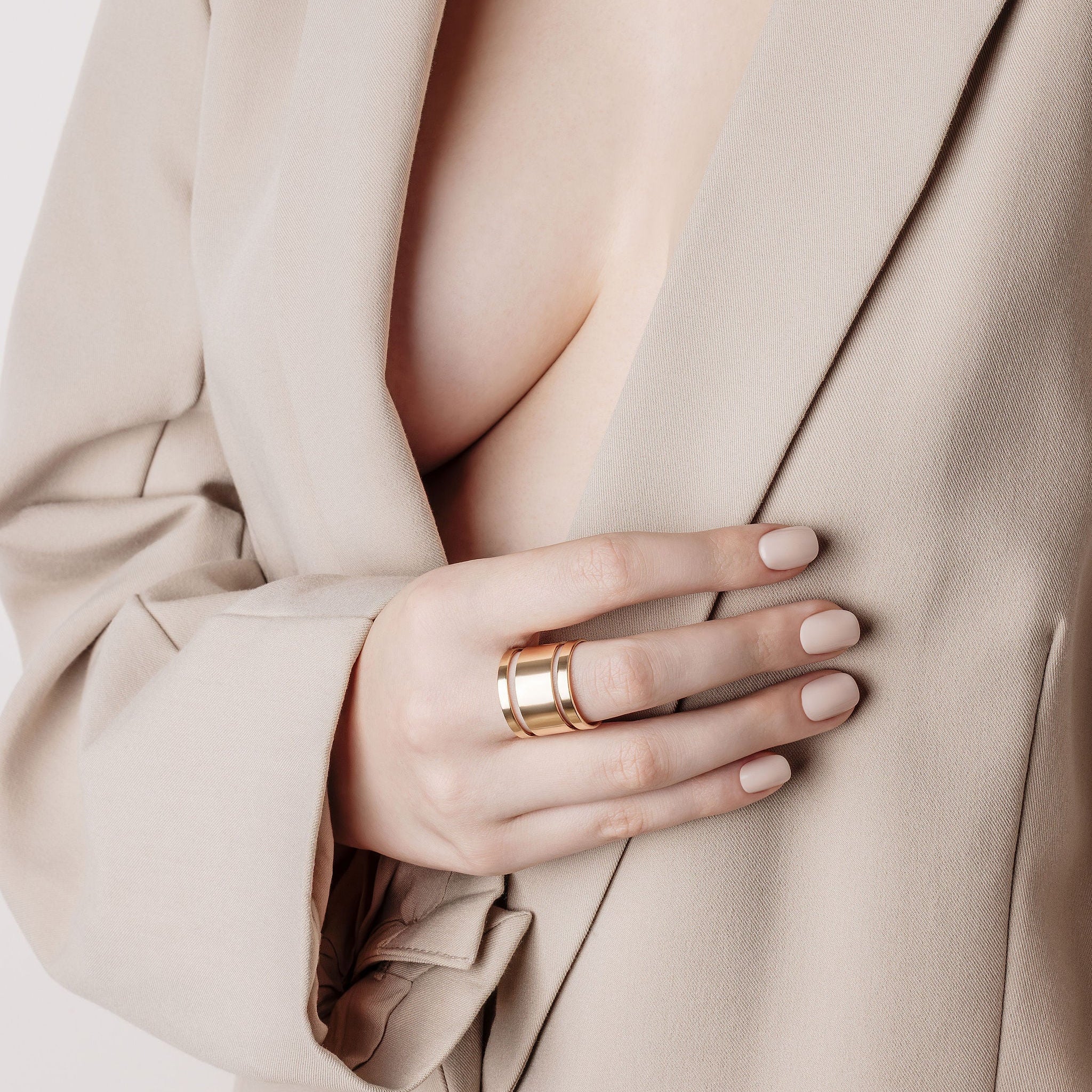 A nude nail colour with attitude, ring on a beige suit jacket.